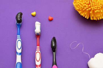 personal hygiene items toothbrushes, dental floss and washcloth on purple background
