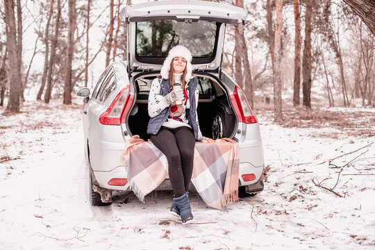 Coffee Break In Winter Park. Pause In Study Outside The City. Out In Nature In Winter.  Girl Driver . Winter Quarantine .
Young Girl Went Out Of Town By Car For A Picnic In Winter.