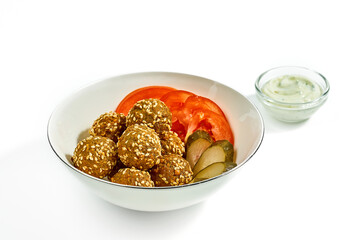 Falafel with cucumbers and tomatoes in a white bowl, white, garlic sauce isolated on a white background