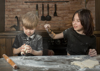 Fototapeta na wymiar brother and sister make cookies out of dough, indulge and have fun