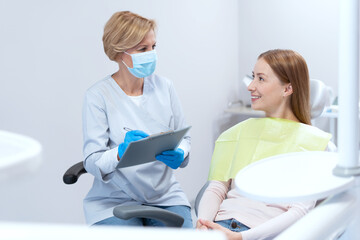 Stomatologist interviewing patient before dental treatment procedure