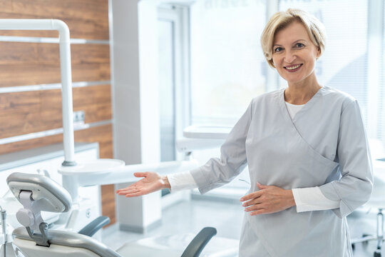 Smiling dentist invites to visit modern stomatology clinic