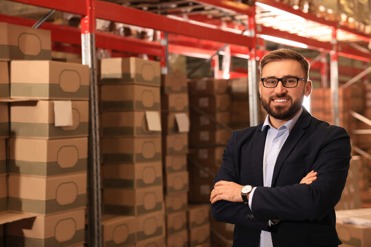 Manager near stacked boxes at warehouse. Logistic center - Powered by Adobe