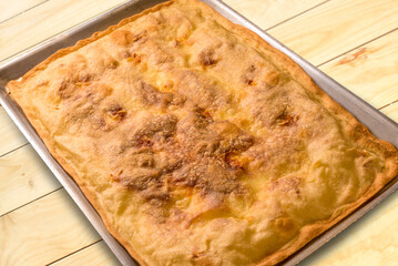 Focaccia from Recco, Liguria, Italy. Soft Cheese focaccia bread made with flour and olive oil in a pan on wooden boards