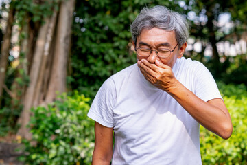 asian older man put a finger over his nose.