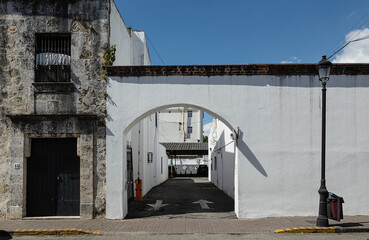 white archway in wall to enter the exclusive parking area for hotel guests.Street view of the arch,San Domingo, capital of the Dominican Republic, January 22, 2022