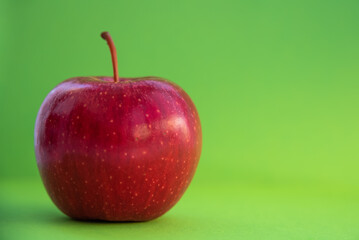A red healthy apple on a green background
