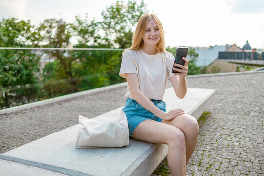 30s Woman Taking Selfie Photo Using Smart Phone App On Smartphone For Social Media Smiling Outside Outdoor On Summer Street. Video Chat Meeting Concept