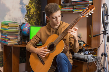 boy playing guitar in his room