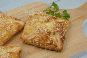 puff pastry with sesame seeds on a wooden board