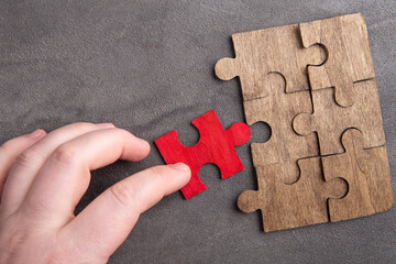 Creative idea and solve the problem concept. Teamwork success strategy - wooden puzzle on the grey...