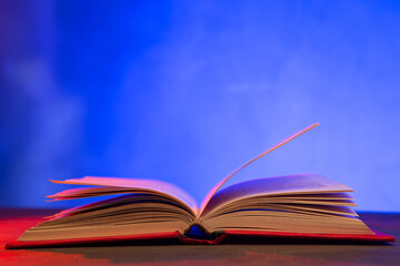 Open book on the table. Education and reading concept. Retro neon light