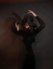a blurry photo of a beautiful girl in a hat and a black dress. defocus