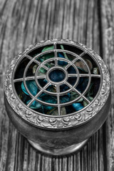 Potpourri in a vintage silver decorated bowl on a wood background.  With selective colour