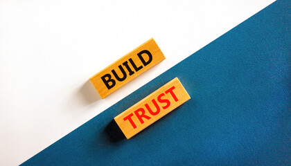 Build trust symbol. Concept words Build trust on wooden blocks on a beautiful blue table white background. Business and build trust concept, copy space.