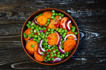 Fototapeta na wymiar Healthy salad with carrots, green peas and blue onions. Vegan diet.