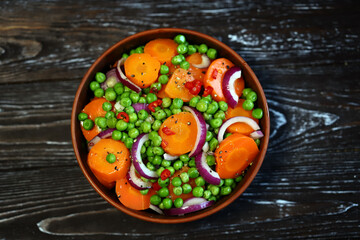 Healthy salad with carrots, green peas and blue onions. Vegan diet.