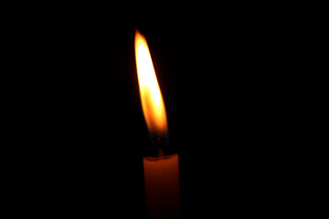 burning candle on black background