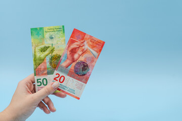 Woman's hand holding euro banknotes on blue background. Money. Business