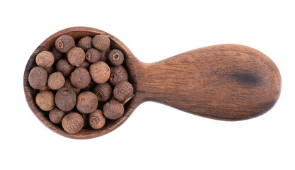 Allspice in wooden spoon, isolated on white background. Jamaican pepper, pimento berry, allspice peppercorns or myrtle pepper. Top view.