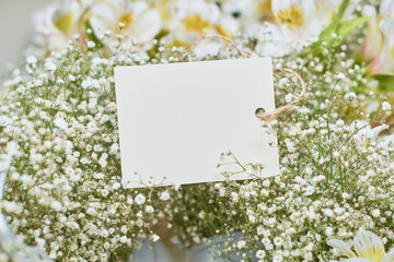 Mock up of blank wedding invitation card and decorative flowers.
