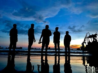 people on the beach at sunset