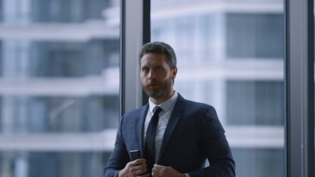Cheerful executive celebrating success enjoying business deal by window office.