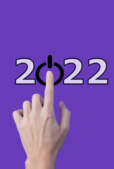 Hand pointing to a conceptual text that indicates 2022 by pressing a button, on
