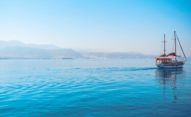 Obraz premium Yacht in the bay against the backdrop of the hills