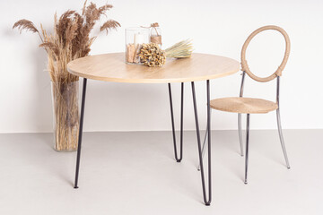 Wooden table, chair and dried flowers on white background. Eco-friendly home furniture