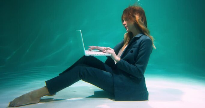 CLIENT SERVICE REPRESENTATIVE Cinematic view of young happy business woman working using laptop underwater slow motion.