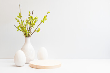 Willow branches in a vase and easter eggs on a light background. Easter background with copy space