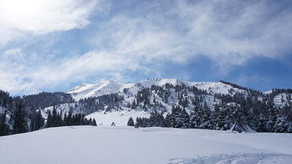 Fototapeta na wymiar Snow-white mountain peaks under clouds on a clear frosty day