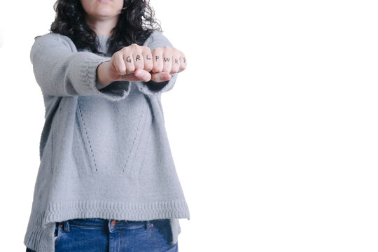 An unrecognizable woman's hand with the letters GRL and PWR drawn on her fingers. Feminism concept. Copy space