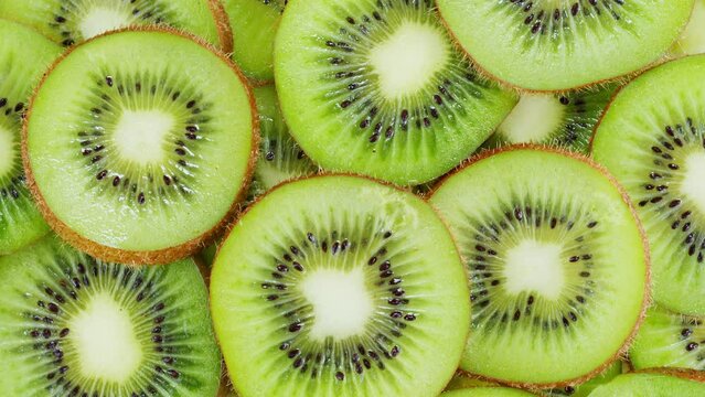 Green kiwi rotating top view, fresh and ripe sweet fruits circles. Healthy eating, vitamins, vegetarian lifestyle.