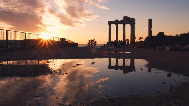 Sunset at side ancient city in Antalya Turkey, silhouettes of the temple of Apollon with Reflection on water.