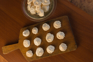 Delicious crispy homemade egg meringue, prepared with love on a wooden background, crunchy dessert for coffee or tea.