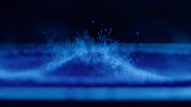 Subwoofer with blue paint powder. Bass speaker, loud music volume macro shooting. Professional disco studio equipment. Playback of musical stereo system, vibration, acoustic sound.