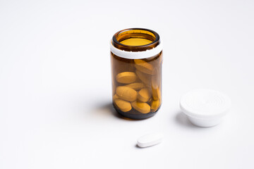 Bottle of white pills on white background  with copy space