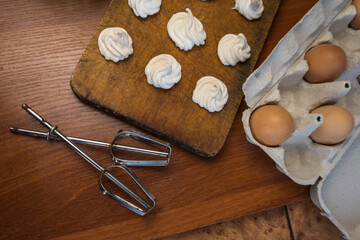Delicious crispy homemade egg meringue, prepared with love on a wooden background, crunchy dessert for coffee or tea.