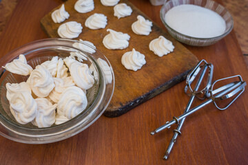 Delicious crispy homemade egg meringue, prepared with love on a wooden background, crunchy dessert for coffee or tea.