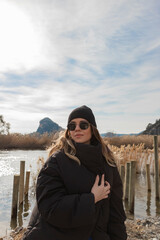 Happy tourist girl in front of reeds of Dalyan River in Turkey. She has sun glasses and hat. 
