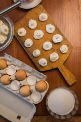 Delicious crispy homemade egg meringue, prepared with love on a wooden background, crunchy dessert for coffee or tea.