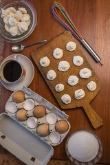 Delicious crispy homemade egg meringue, prepared with love on a wooden background, crunchy dessert for coffee or tea.