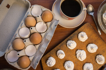 Obraz na płótnie Canvas Delicious crispy homemade egg meringue, prepared with love on a wooden background, crunchy dessert for coffee or tea.