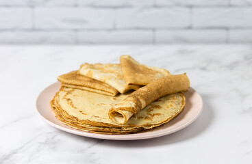 Homemade pancakes, delicious thin pancakes on a pink plate. Selective focus. Russian, thin pancakes