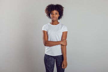 African american woman with puffy hair in a white t-shirt on a white background. Mock-up.