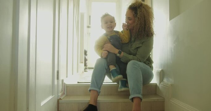 Mother Lifting Up Toddler at Home in Hallway