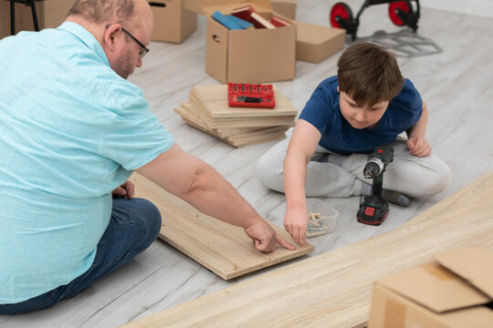 The father shows his son what and where to put the screws.