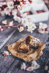 Spring collection of handmade chocolate bonbons candies and cherry flowers decoration on rustic wooden background